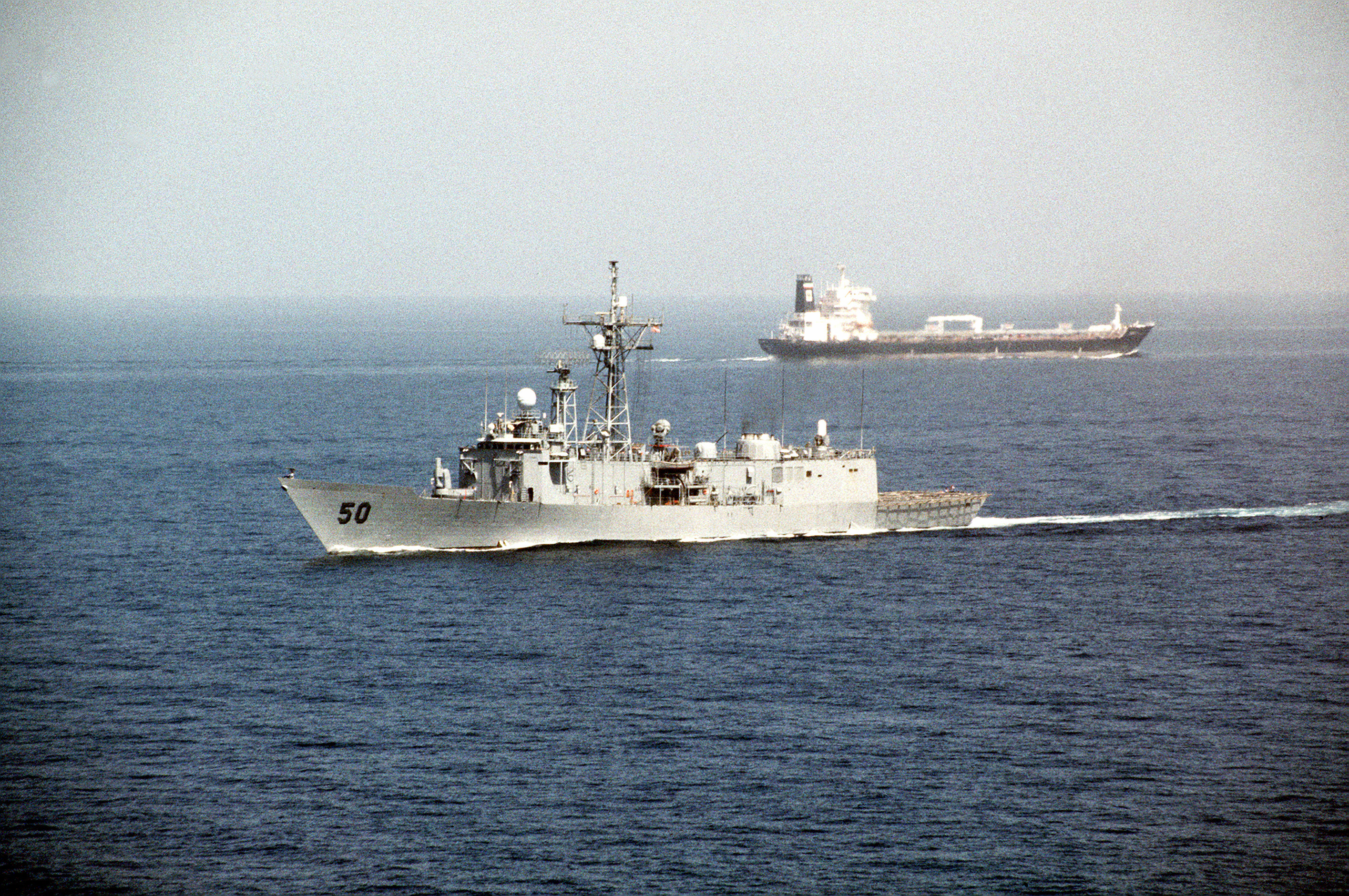USS TAYLOR (FFG-50) passes a tanker after transiting the Strait of Hormuz during Operation Desert Shield.